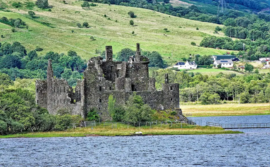 I resti del Kilchurn Castle sulle rive del Loch Awe, circondati da colline verdi
